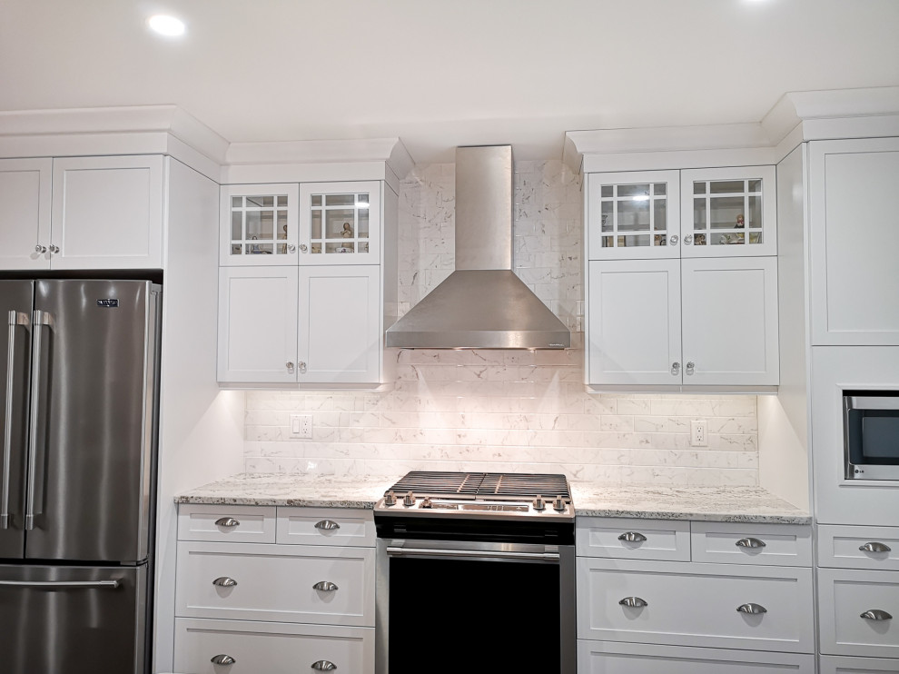 Example of a mid-sized cottage single-wall vinyl floor and brown floor eat-in kitchen design in Toronto with an undermount sink, shaker cabinets, white cabinets, quartz countertops, white backsplash, ceramic backsplash, stainless steel appliances, an island and multicolored countertops