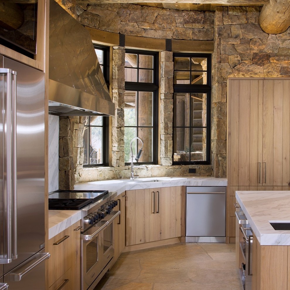 Aménagement d'une cuisine montagne en U et bois clair avec îlot, plan de travail en marbre et un électroménager en acier inoxydable.