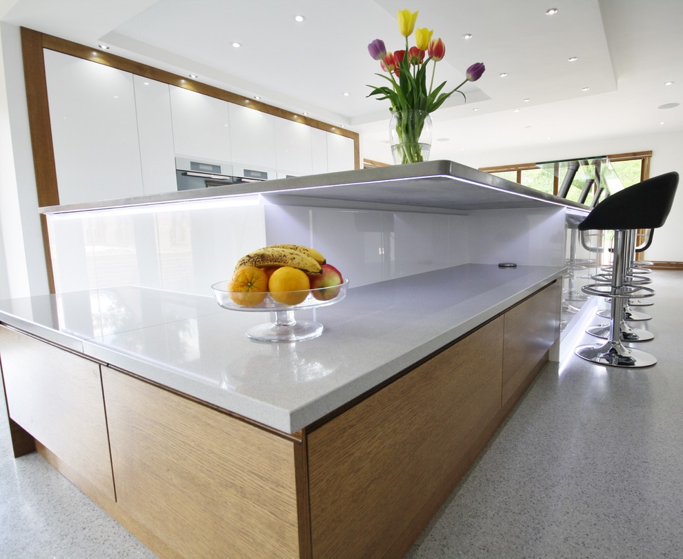 Example of a minimalist kitchen design in Essex with an island