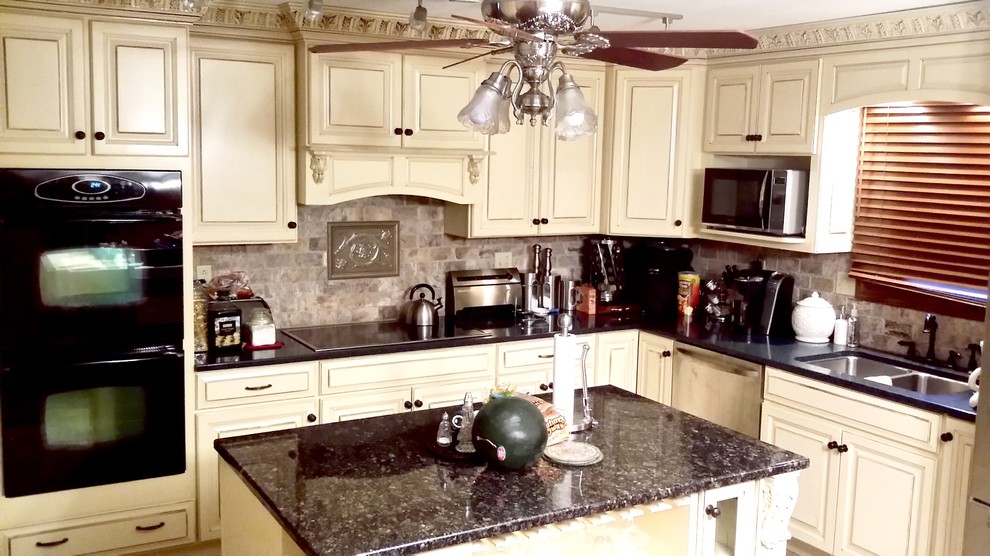 Immagine di una cucina chic di medie dimensioni con top in granito, paraspruzzi con piastrelle in pietra, lavello a doppia vasca, ante con bugna sagomata, ante beige, paraspruzzi grigio e elettrodomestici neri