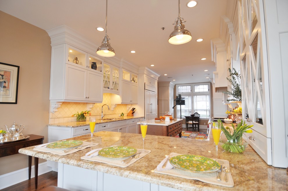Inspiration for a large transitional galley medium tone wood floor eat-in kitchen remodel in New York with an undermount sink, an island, shaker cabinets, white cabinets, granite countertops, beige backsplash, ceramic backsplash and white appliances