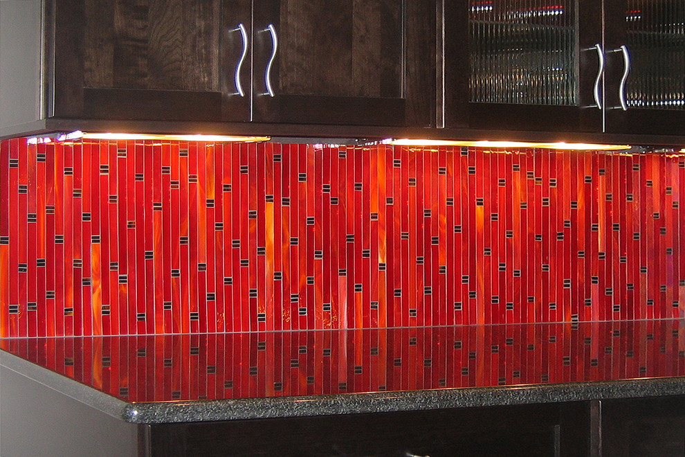 Immagine di una cucina contemporanea di medie dimensioni con lavello sottopiano, ante con riquadro incassato, ante in legno bruno, top in granito, paraspruzzi rosso, paraspruzzi con piastrelle a mosaico, elettrodomestici in acciaio inossidabile e pavimento in marmo