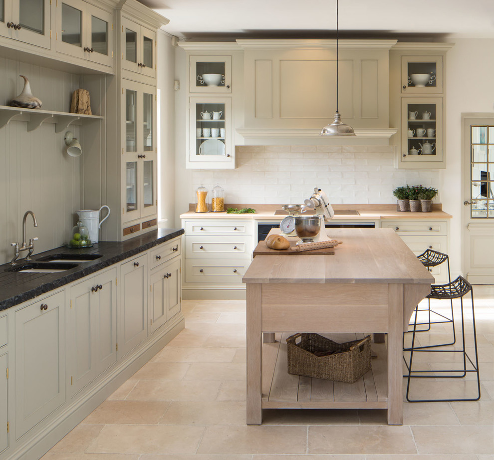 Photo of a large traditional kitchen in Dublin with glass-front cabinets, beige cabinets, white splashback, metro tiled splashback and an island.