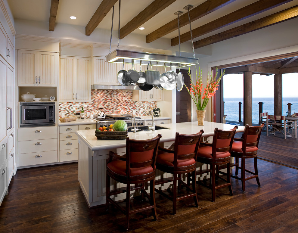 Exempel på ett mellanstort rustikt kök, med en dubbel diskho, vita skåp, flerfärgad stänkskydd, rostfria vitvaror, mellanmörkt trägolv, en köksö och luckor med infälld panel