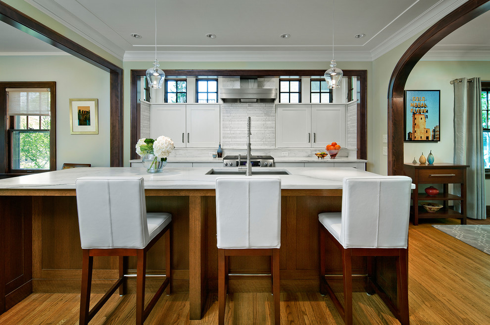 На фото: параллельная кухня в классическом стиле с врезной мойкой, фасадами в стиле шейкер, белыми фасадами, белым фартуком и фартуком из плитки мозаики