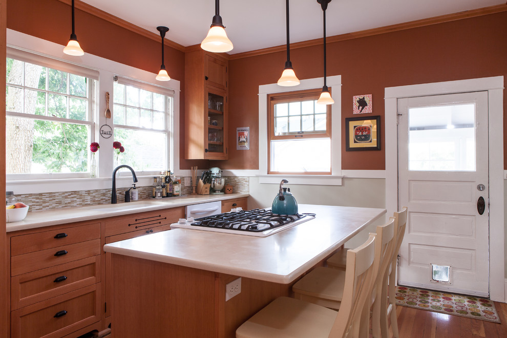 Inspiration for a timeless l-shaped kitchen remodel in Portland with an undermount sink, shaker cabinets, medium tone wood cabinets, multicolored backsplash and white appliances