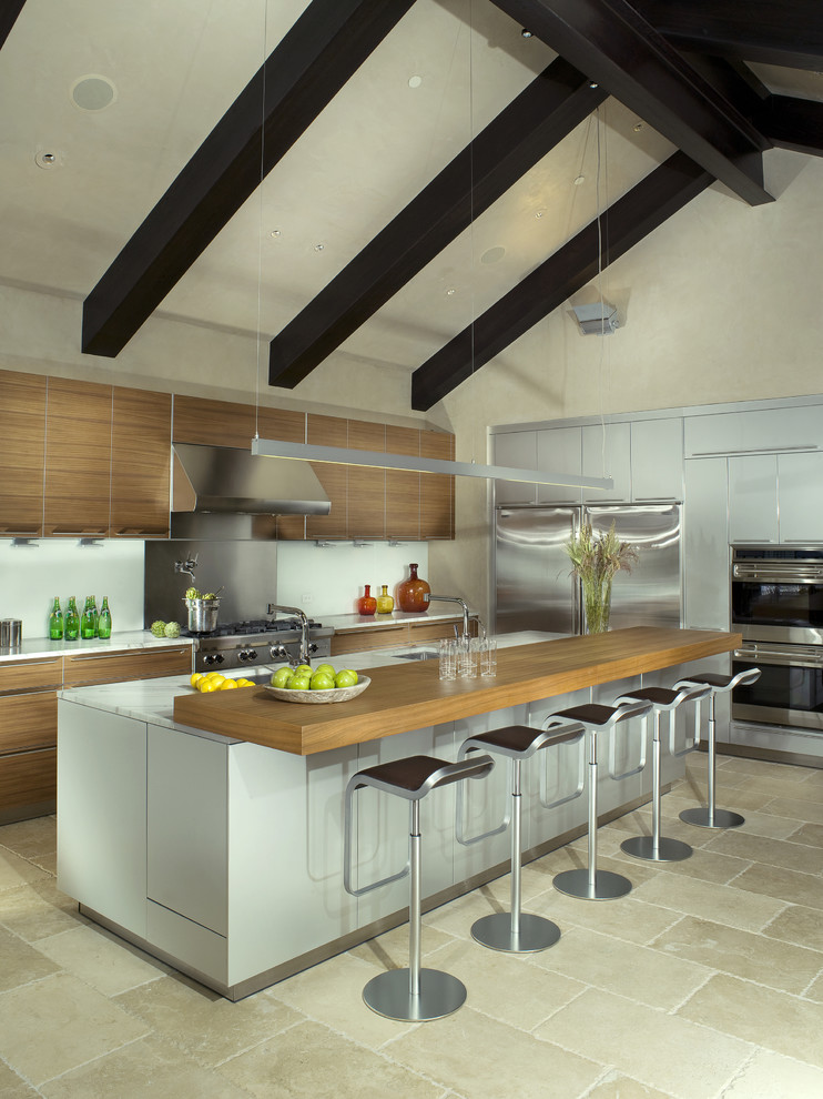 Diseño de cocina actual con electrodomésticos de acero inoxidable, encimera de madera y barras de cocina