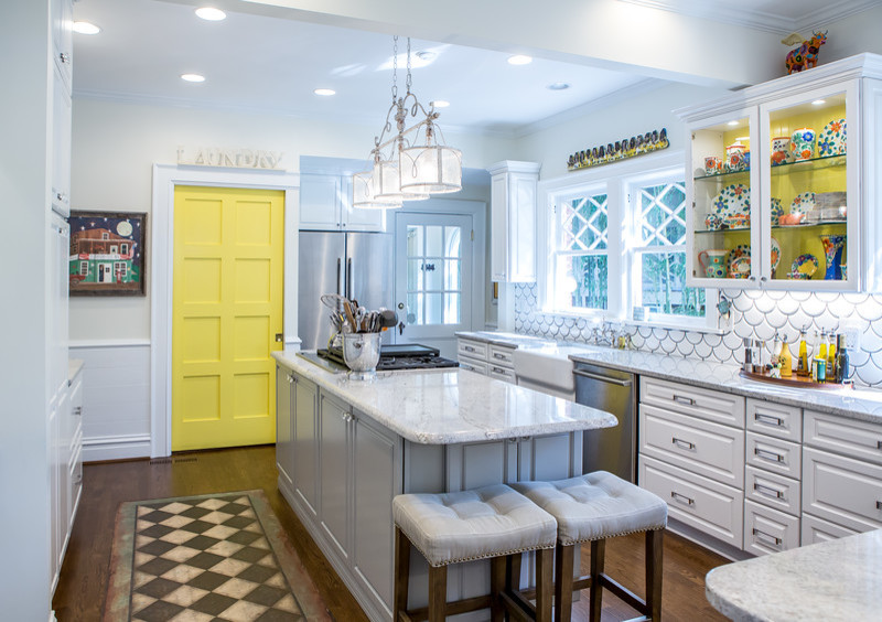 Inspiration for a mid-sized eclectic dark wood floor eat-in kitchen remodel in Atlanta with a farmhouse sink, raised-panel cabinets, white cabinets, granite countertops, white backsplash, ceramic backsplash, stainless steel appliances and an island