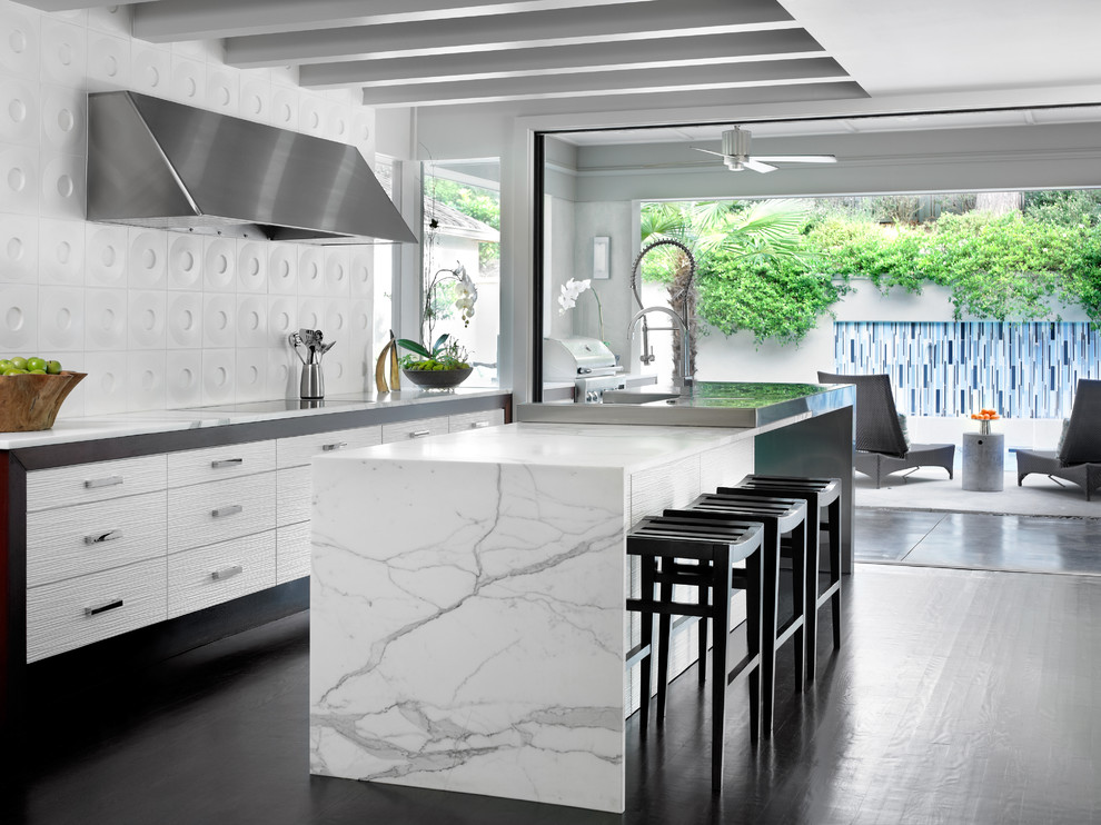 This is an example of a modern galley kitchen in Atlanta with flat-panel cabinets, white cabinets and white splashback.