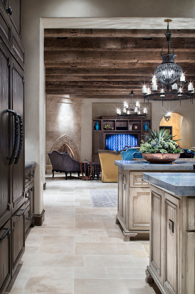 Пример оригинального дизайна: огромная кухня-гостиная в средиземноморском стиле с врезной мойкой, фасадами с утопленной филенкой, фасадами цвета дерева среднего тона, разноцветным фартуком, фартуком из плитки мозаики, цветной техникой, мраморным полом, двумя и более островами, бежевым полом и синей столешницей