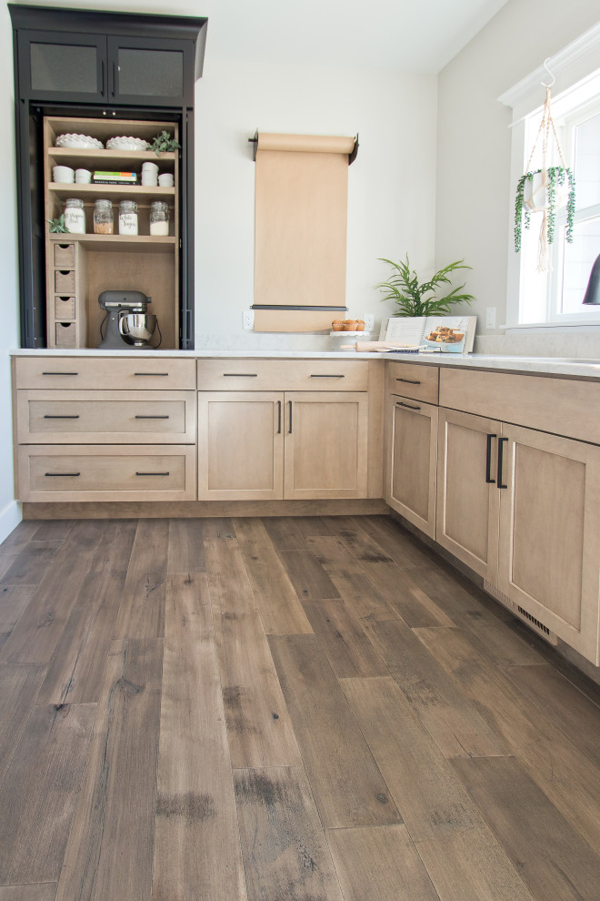 Exempel på ett avskilt lantligt vit vitt l-kök, med en undermonterad diskho, luckor med infälld panel, skåp i ljust trä, bänkskiva i kvarts, rostfria vitvaror, mellanmörkt trägolv och brunt golv