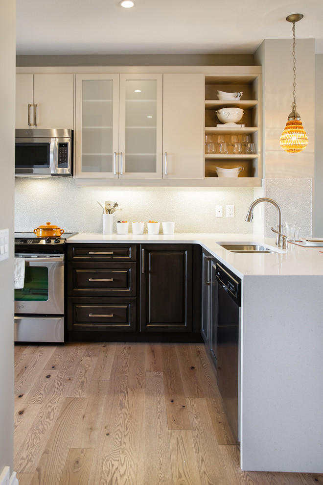 Ejemplo de cocina actual con armarios con paneles con relieve, electrodomésticos de acero inoxidable y puertas de armario de madera en tonos medios