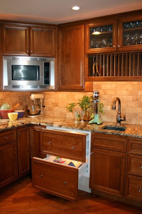 Eat-in kitchen - large traditional l-shaped medium tone wood floor eat-in kitchen idea in Denver with a single-bowl sink, flat-panel cabinets, medium tone wood cabinets, granite countertops, beige backsplash, subway tile backsplash, stainless steel appliances and no island