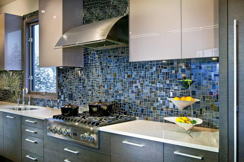 Inspiration for a medium sized modern single-wall open plan kitchen in New York with a submerged sink, flat-panel cabinets, grey cabinets, soapstone worktops, blue splashback, mosaic tiled splashback and stainless steel appliances.