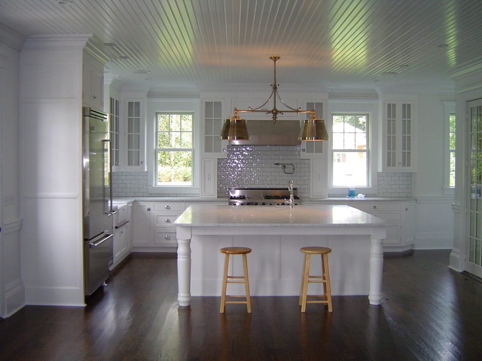Large cottage l-shaped dark wood floor eat-in kitchen photo in New York with an undermount sink, beaded inset cabinets, white cabinets, marble countertops, white backsplash, porcelain backsplash, stainless steel appliances and an island