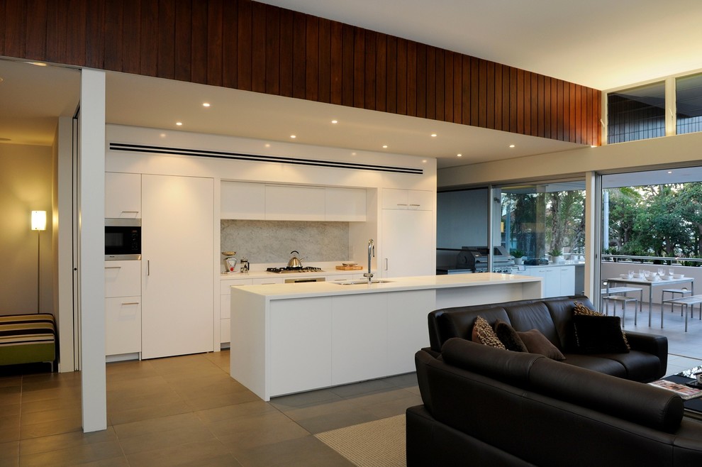 Diseño de cocina comedor lineal contemporánea con salpicadero verde, electrodomésticos de acero inoxidable y una isla