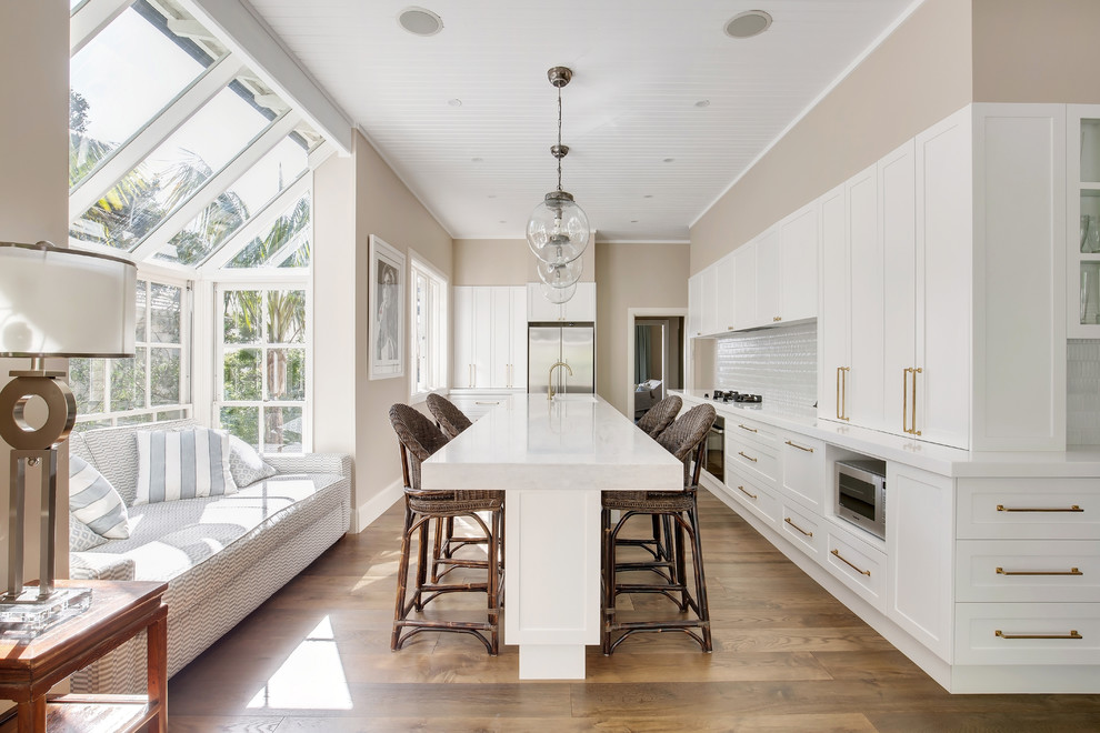 Exempel på ett mycket stort klassiskt vit vitt kök, med en undermonterad diskho, skåp i shakerstil, vita skåp, bänkskiva i koppar, vitt stänkskydd, stänkskydd i tunnelbanekakel, rostfria vitvaror, mellanmörkt trägolv, en köksö och brunt golv