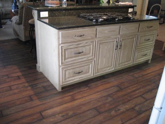 Foto di una cucina tradizionale di medie dimensioni con ante con bugna sagomata, ante con finitura invecchiata, top in granito, parquet scuro e pavimento marrone