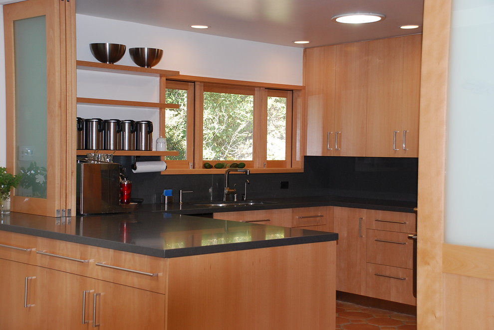 Стильный дизайн: отдельная, п-образная кухня среднего размера в стиле модернизм с плоскими фасадами, светлыми деревянными фасадами, серым фартуком, техникой из нержавеющей стали, полом из терракотовой плитки и полуостровом - последний тренд