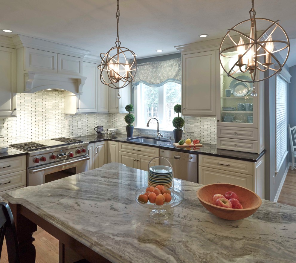 Example of a large classic u-shaped eat-in kitchen design in Boston with a single-bowl sink, raised-panel cabinets, white cabinets, granite countertops, white backsplash, glass tile backsplash, stainless steel appliances and an island