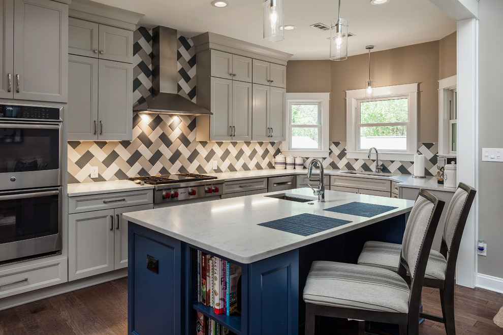 Inspiration for a mid-sized timeless l-shaped medium tone wood floor and brown floor open concept kitchen remodel in Charlotte with a single-bowl sink, recessed-panel cabinets, gray cabinets, quartzite countertops, ceramic backsplash, stainless steel appliances, an island and white countertops