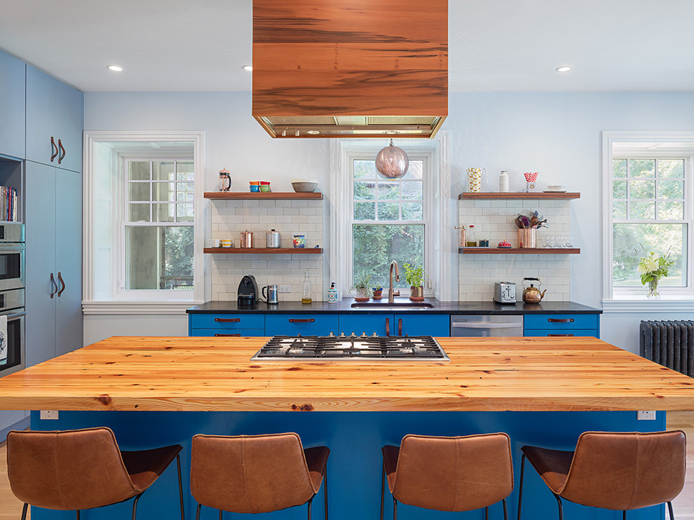 Foto di un cucina con isola centrale contemporaneo con lavello sottopiano, ante lisce, ante blu, top in legno, paraspruzzi bianco, paraspruzzi con piastrelle diamantate e elettrodomestici in acciaio inossidabile