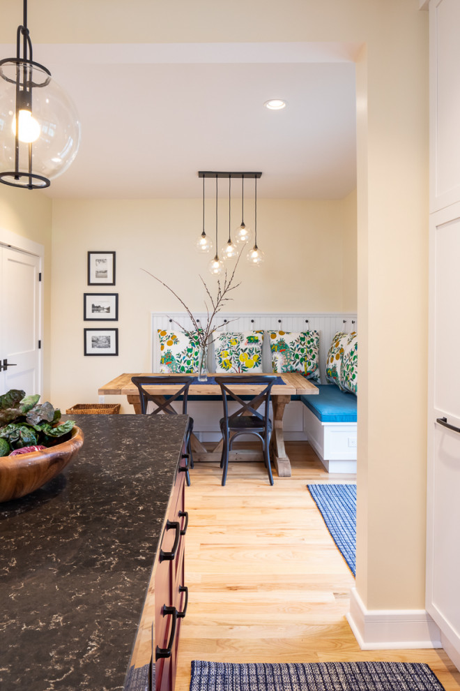Exempel på ett mellanstort amerikanskt brun brunt kök, med en undermonterad diskho, skåp i shakerstil, vita skåp, bänkskiva i kvarts, blått stänkskydd, stänkskydd i porslinskakel, rostfria vitvaror, ljust trägolv, en köksö och gult golv