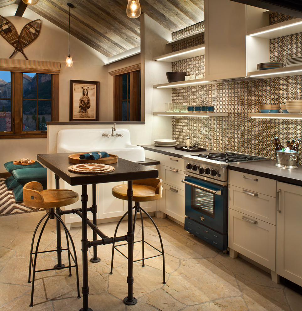 Rustic l-shaped kitchen in Denver with a belfast sink, shaker cabinets, white cabinets, multi-coloured splashback, coloured appliances and an island.