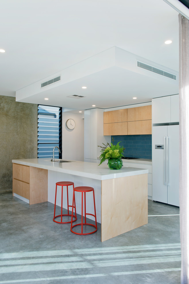 Inspiration pour une cuisine parallèle minimaliste en bois clair de taille moyenne avec un placard à porte plane, un électroménager blanc et îlot.