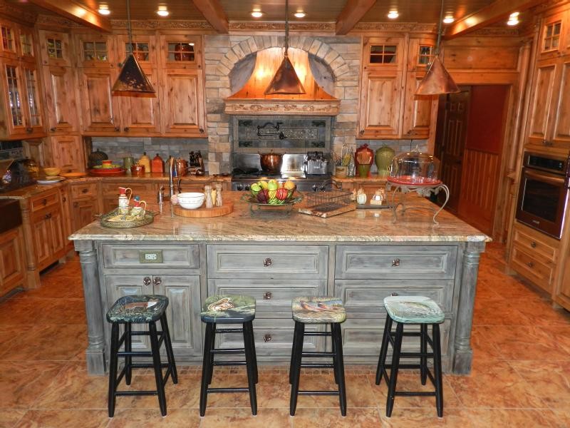 Inspiration för ett stort rustikt kök, med en rustik diskho, luckor med upphöjd panel, skåp i mellenmörkt trä, granitbänkskiva, grått stänkskydd, stänkskydd i stenkakel, rostfria vitvaror, klinkergolv i keramik och en köksö
