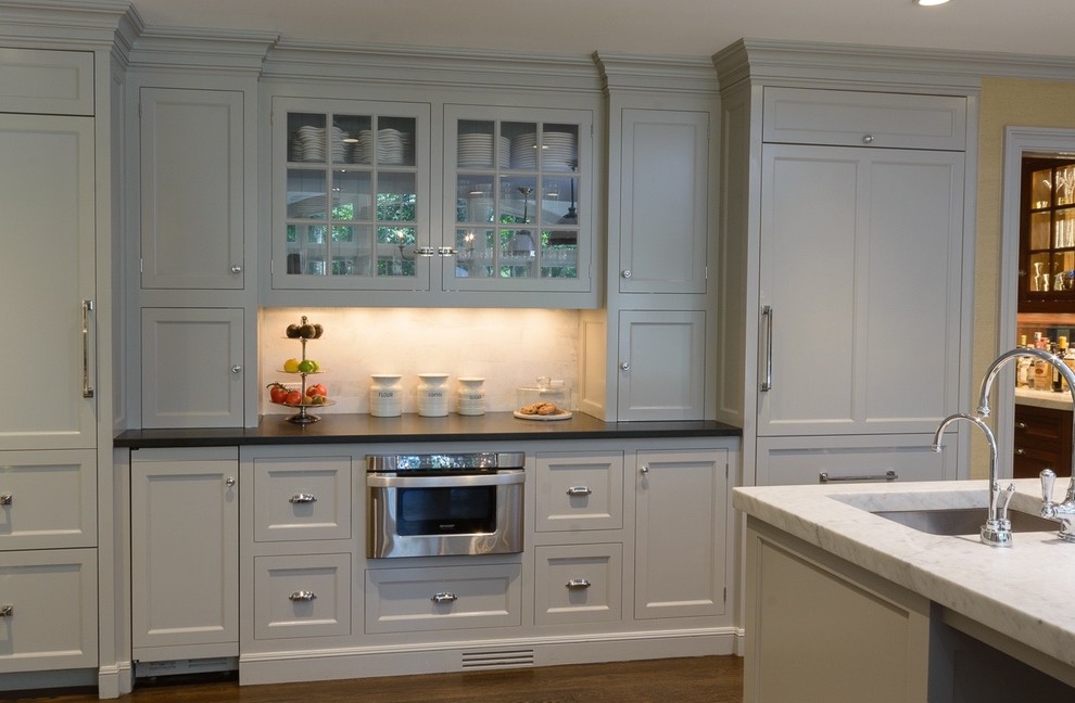 Example of a huge transitional l-shaped dark wood floor eat-in kitchen design in New York with an undermount sink, recessed-panel cabinets, gray cabinets, marble countertops, gray backsplash, stone tile backsplash, paneled appliances and an island