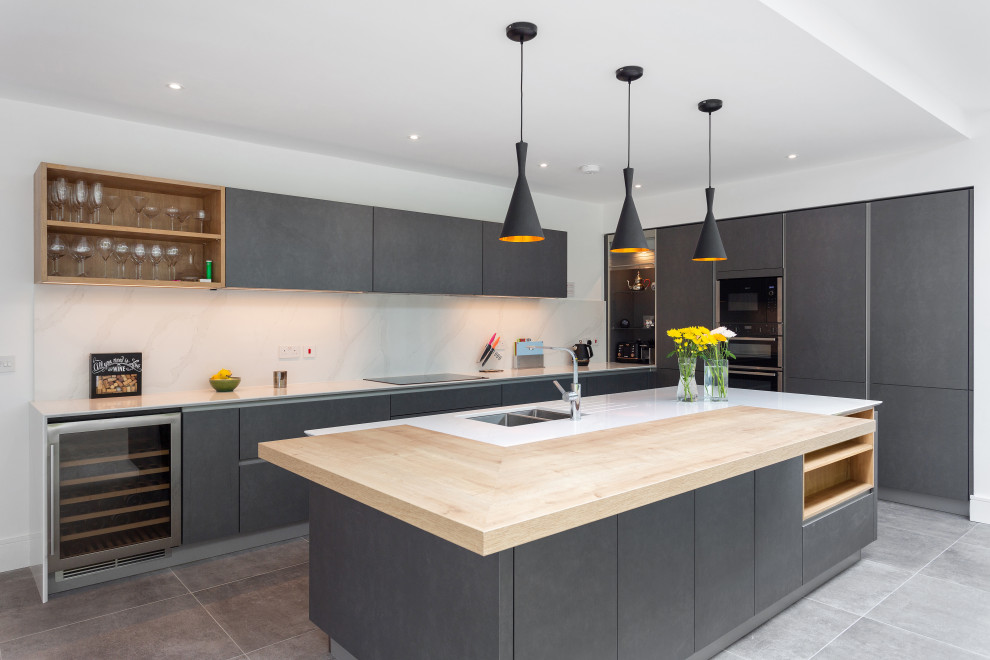 Moderne Küche in L-Form mit Unterbauwaschbecken, flächenbündigen Schrankfronten, grauen Schränken, Kücheninsel, grauem Boden und weißer Arbeitsplatte in Dublin