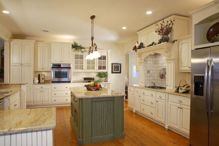 Eat-in kitchen - large traditional u-shaped medium tone wood floor eat-in kitchen idea in Chicago with raised-panel cabinets, white cabinets, granite countertops, stone tile backsplash, stainless steel appliances, an island and beige backsplash