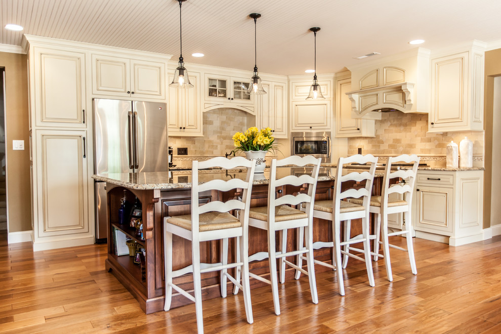Design ideas for a mid-sized traditional u-shaped eat-in kitchen in Chicago with a farmhouse sink, beaded inset cabinets, white cabinets, granite benchtops, porcelain splashback, stainless steel appliances, light hardwood floors and with island.