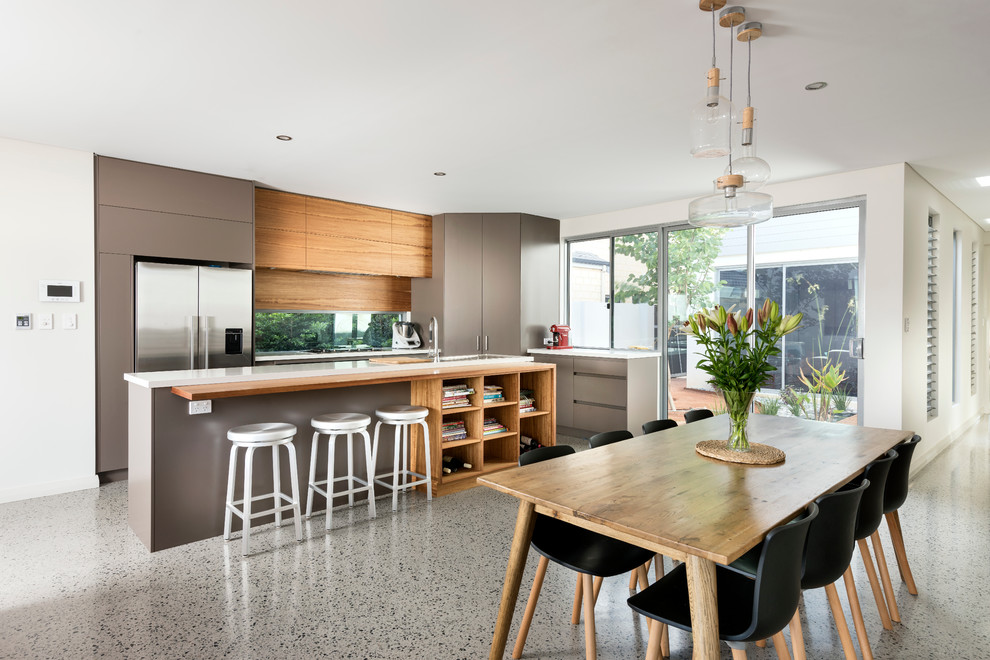 Immagine di una cucina contemporanea di medie dimensioni con lavello sottopiano, top in quarzo composito, paraspruzzi con lastra di vetro, elettrodomestici in acciaio inossidabile e pavimento in cemento
