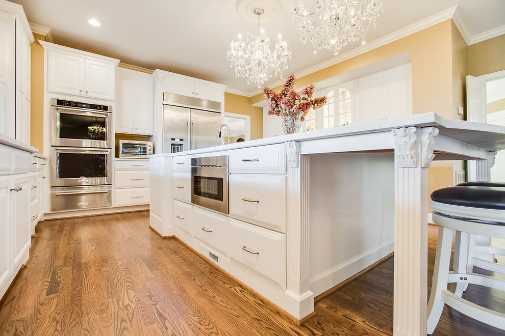 Design ideas for a large classic l-shaped kitchen/diner in Birmingham with raised-panel cabinets, white cabinets, engineered stone countertops, stainless steel appliances and an island.