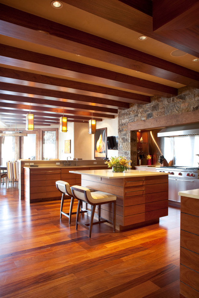 Esempio di un cucina con isola centrale minimal con ante lisce, ante in legno scuro e top in quarzo composito