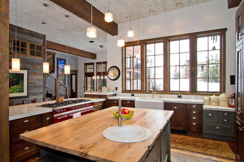 Eclectic kitchen photo in Denver with wood countertops, a farmhouse sink, dark wood cabinets and colored appliances