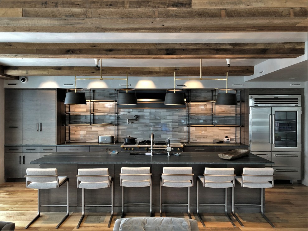 Eat-in kitchen - large contemporary u-shaped medium tone wood floor and brown floor eat-in kitchen idea in Denver with a farmhouse sink, flat-panel cabinets, light wood cabinets, stainless steel appliances, an island, black countertops, soapstone countertops, gray backsplash and marble backsplash