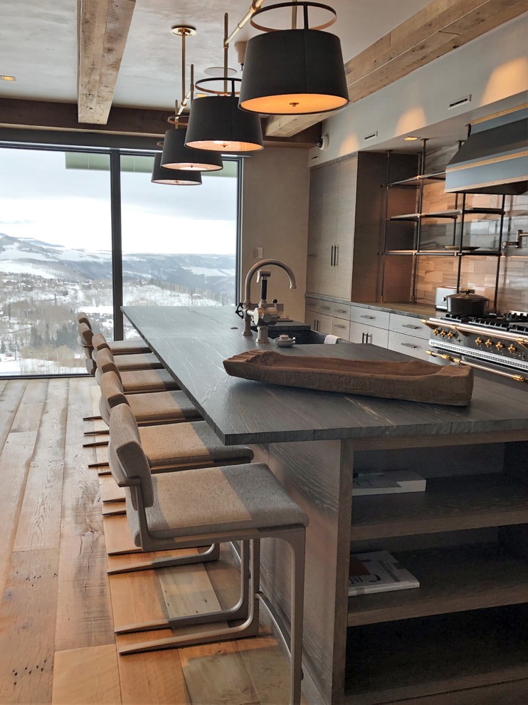 Eat-in kitchen - large contemporary u-shaped medium tone wood floor and brown floor eat-in kitchen idea in Denver with a farmhouse sink, flat-panel cabinets, light wood cabinets, quartzite countertops, beige backsplash, porcelain backsplash, stainless steel appliances, an island and black countertops