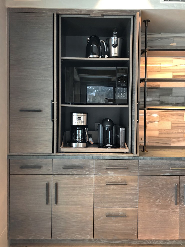 Example of a large trendy u-shaped medium tone wood floor and brown floor eat-in kitchen design in Denver with a farmhouse sink, flat-panel cabinets, light wood cabinets, stainless steel appliances, an island, concrete countertops, gray backsplash, marble backsplash and gray countertops