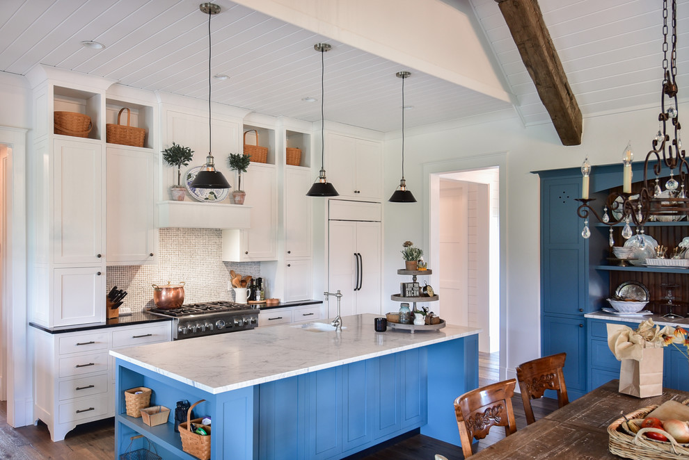 Inspiration for a farmhouse u-shaped open plan kitchen in Other with a submerged sink, shaker cabinets, white cabinets, marble worktops, white splashback, mosaic tiled splashback, integrated appliances, dark hardwood flooring, an island, brown floors and white worktops.