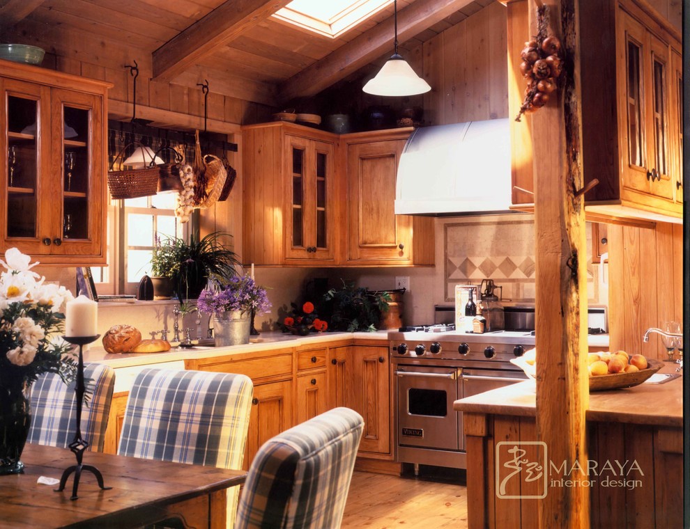 Exempel på ett litet lantligt kök, med en enkel diskho, luckor med infälld panel, skåp i slitet trä, träbänkskiva, beige stänkskydd, stänkskydd i stenkakel, rostfria vitvaror, ljust trägolv och en halv köksö