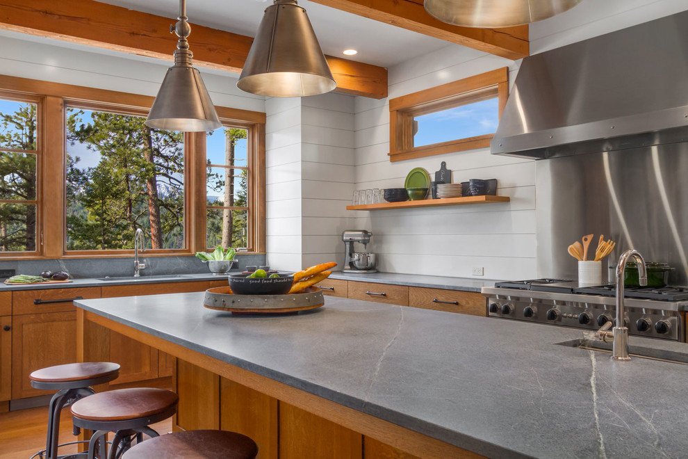Eat-in kitchen - mid-sized traditional u-shaped medium tone wood floor eat-in kitchen idea in Seattle with an undermount sink, flat-panel cabinets, medium tone wood cabinets, granite countertops, white backsplash, stainless steel appliances and an island