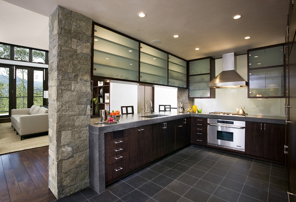 Пример оригинального дизайна: п-образная кухня в современном стиле с столешницей из бетона, монолитной мойкой, плоскими фасадами, темными деревянными фасадами, белым фартуком, фартуком из стекла и техникой из нержавеющей стали