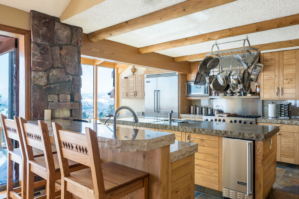 Immagine di una cucina stile rurale con lavello sottopiano, ante in legno chiaro, top in granito, paraspruzzi in lastra di pietra, elettrodomestici in acciaio inossidabile e 2 o più isole