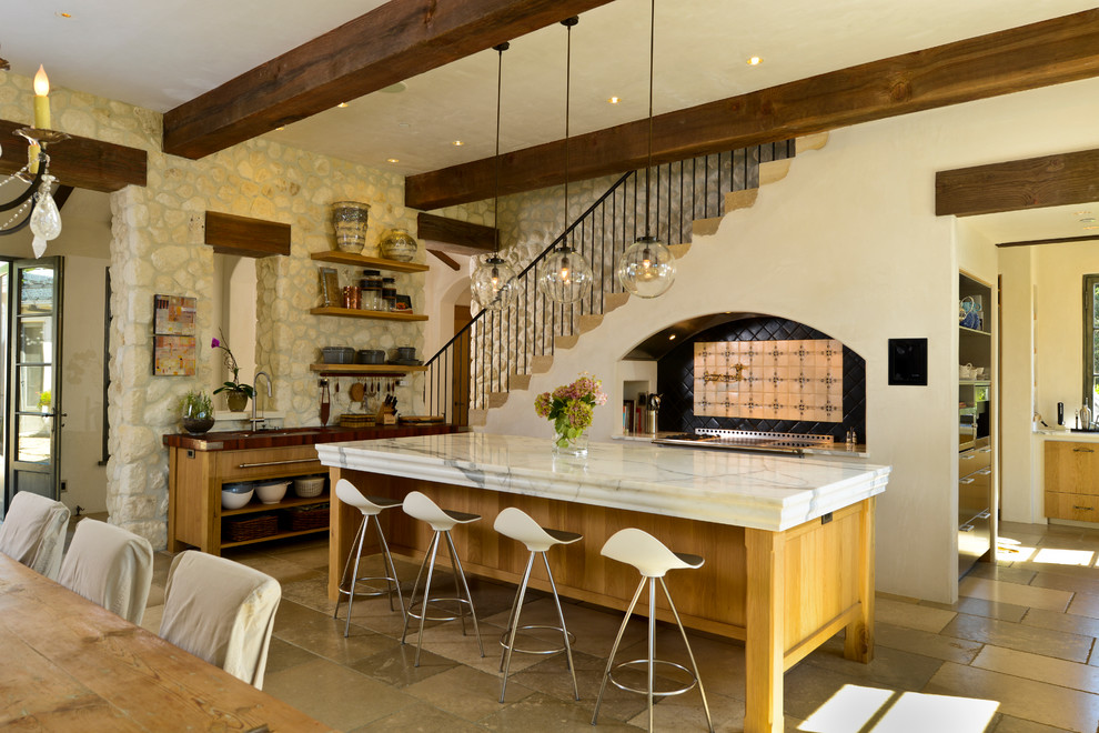 Foto på ett medelhavsstil kök med öppen planlösning, med skåp i mellenmörkt trä, släta luckor och skiffergolv