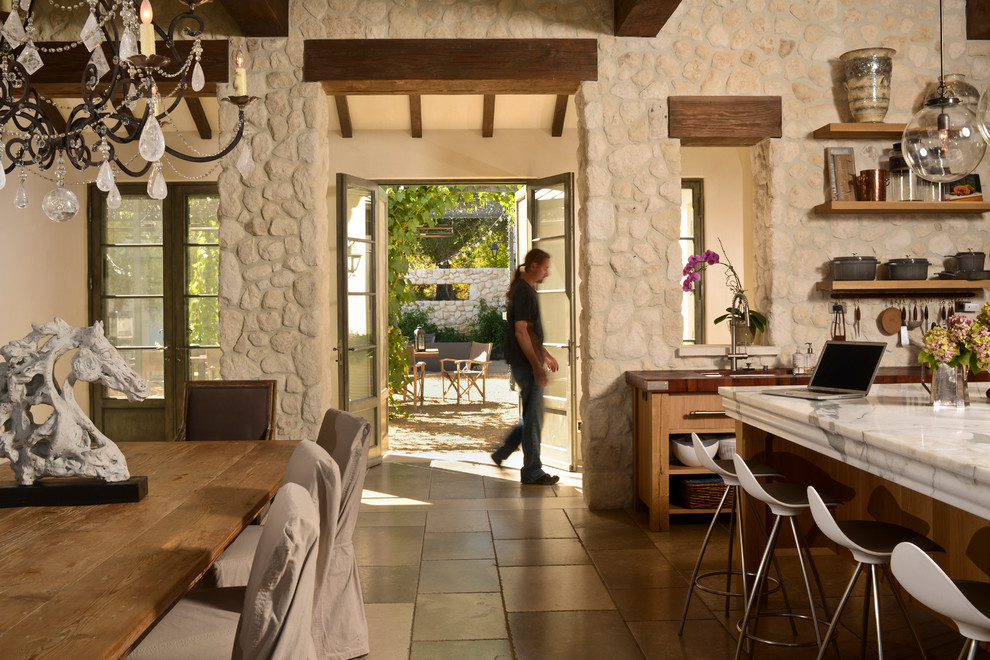 サンフランシスコにある地中海スタイルのおしゃれなダイニングキッチン (フラットパネル扉のキャビネット、淡色木目調キャビネット、木材カウンター、スレートの床) の写真