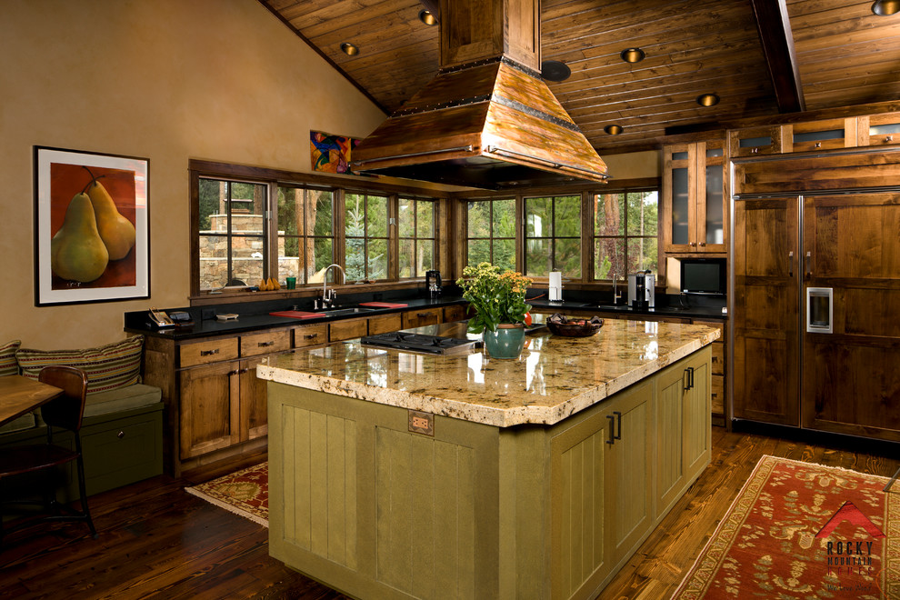 Cette photo montre une cuisine ouverte montagne en L et bois brun de taille moyenne avec un placard avec porte à panneau encastré et îlot.