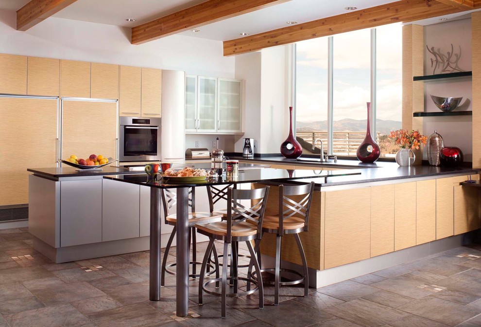 Photo of an expansive contemporary u-shaped kitchen/diner in Denver with flat-panel cabinets, light wood cabinets, integrated appliances, a submerged sink, slate flooring, multiple islands and multi-coloured floors.